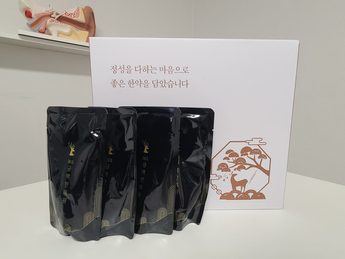 검은 한약 파우치 세 개와 금맥한의원 상자