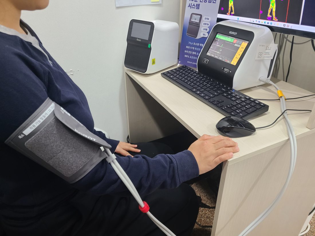 팔에 혈압계를 감고 혈압과 맥파를 함께 재는 장면
