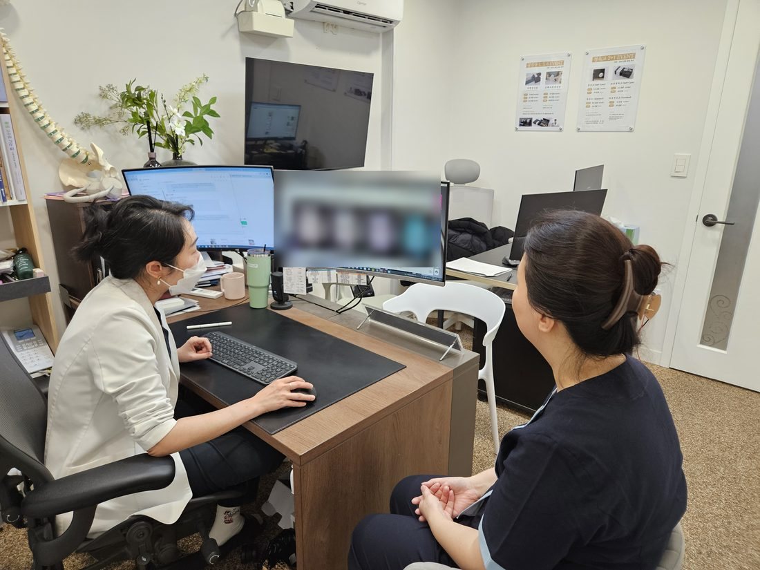 원장이 피부 분석 화면을 보며 환자와 상담하는 장면